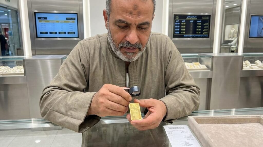 شخص مصري يتأكد من جودة الدمغة بالليزر على سبيكة ذهبية داخل محل صاغة لتجنب الغش